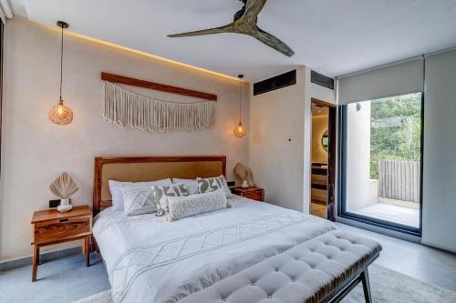 a bedroom with a large bed and a large window at Jungle Villa Tulum in Balcheil