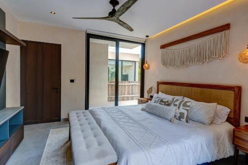 a bedroom with a large bed with a large window at Jungle Villa Tulum in Balcheil