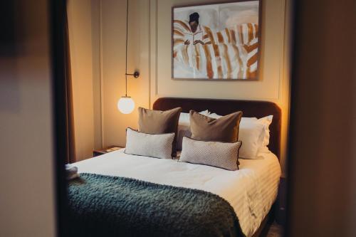 a bedroom with a bed with white sheets and pillows at The Wheatley Arms in Ilkley