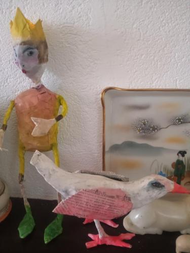 a figurine of a man and a chicken next to a mirror at Villa Erbetta in Guardabosone