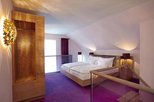 a bedroom with a bed and a staircase in it at abito Suites in Leipzig