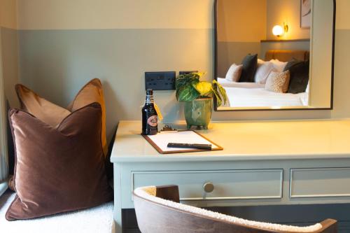 a room with a bed and a desk with a mirror at The Wheatley Arms in Ilkley