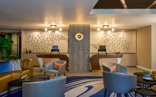 a lobby with a waiting area with chairs and tables at Hyatt Centric South Beach Miami in Miami Beach