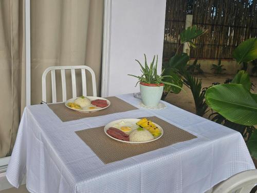 a table with two plates of food on it at Lio Palm Villas in Langi-langiban