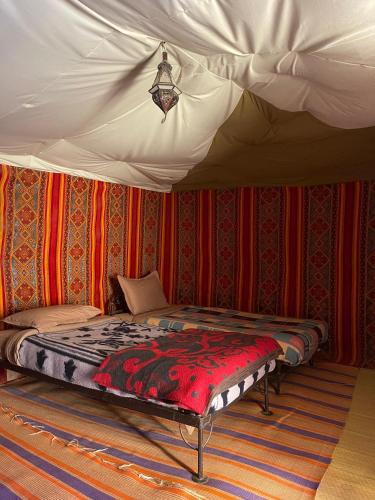 a bedroom with a bed in a tent at Nomada Desert Camp in Merzouga