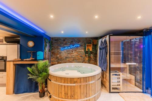 La salle de bains est pourvue d'une grande baignoire en bois et d'une douche. dans l'établissement Un metre sous Terre & Mer SPA - Wellness - Loveroom, à Herrlisheim