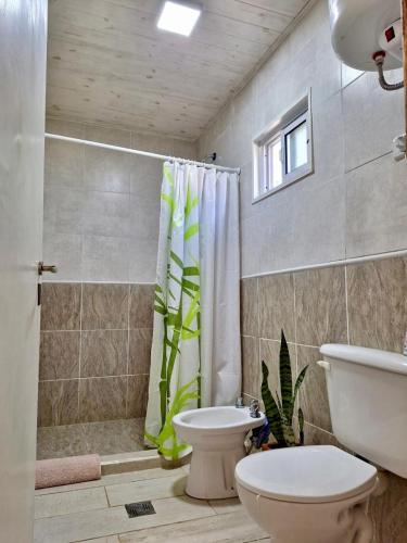 a bathroom with a toilet and a shower curtain at Mis Cabañas La Misión in Salta