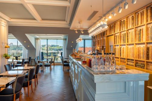 a restaurant with a bar with tables and chairs at CBR Boutique Hotel - Coimbra in Coimbra