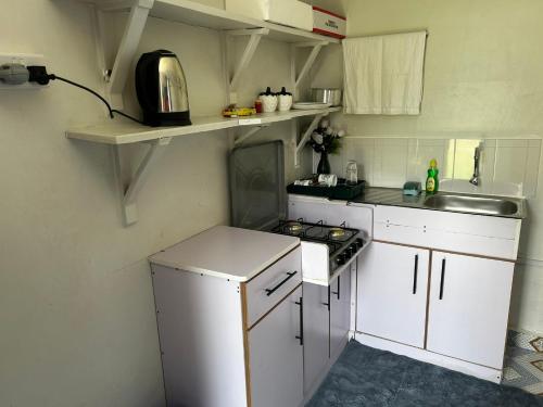 a small kitchen with a stove and a sink at Jymia BnB in Kitale