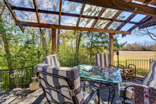 a patio with a glass table and chairs on a deck at College Station Getaway with Hot Tub and Courtyard! in College Station