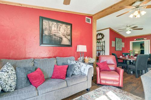 a living room with a couch and a red wall at College Station Getaway with Hot Tub and Courtyard! in College Station