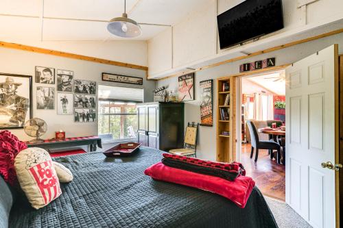 a living room with a bed with a red blanket at College Station Getaway with Hot Tub and Courtyard! in College Station