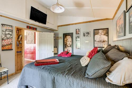 a bedroom with a bed with pillows and posters on the walls at College Station Getaway with Hot Tub and Courtyard! in College Station