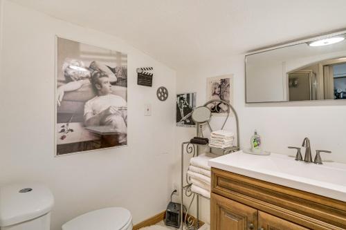 a bathroom with a sink and a toilet and a mirror at College Station Getaway with Hot Tub and Courtyard! in College Station