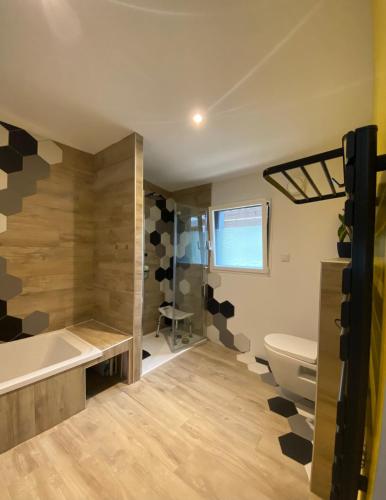 une salle de bain avec une baignoire, des toilettes et un lavabo dans l'établissement Evasion forestiere a Camors Lambel, à Camors