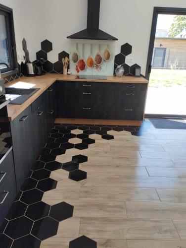 - une cuisine avec un sol noir et blanc dans l'établissement Evasion forestiere a Camors Lambel, à Camors