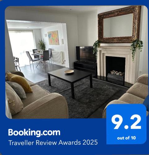a living room with a couch and a fireplace at Modern four bedroom semi-detached house with off street parking 8 min drive to Wembley stadium, 5 miles to Central London in London
