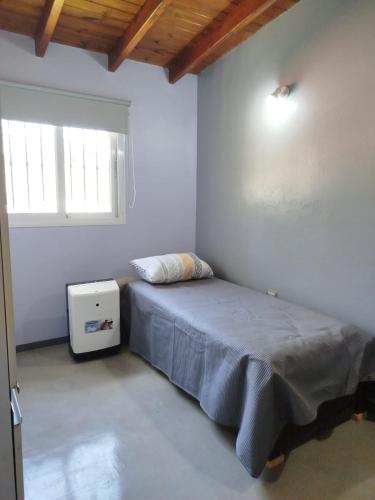 ein Schlafzimmer mit einem Bett in einem Zimmer mit einem Fenster in der Unterkunft Yoyiland in Guaymallen