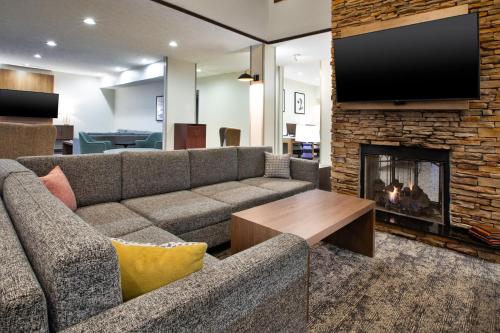 a living room with a couch and a fireplace at Staybridge Suites Omaha 80th and Dodge by IHG in Omaha
