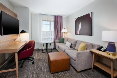 a living room with a couch and a desk at Staybridge Suites Omaha 80th and Dodge by IHG in Omaha