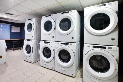 four washers and dryers in a laundry room at Staybridge Suites Omaha 80th and Dodge by IHG in Omaha