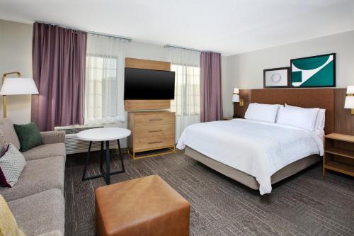 a hotel room with a bed and a couch at Staybridge Suites Omaha 80th and Dodge by IHG in Omaha