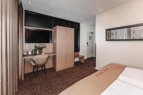 a hotel room with a bed and a desk at Hotel Unique Majestic in Dortmund