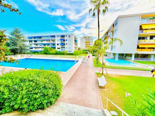 un complexe d'appartements avec piscine et palmiers dans l'établissement NICE La Palmeraie Pool BEACH AC, à Nice