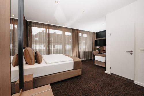 a hotel room with a bed and a bedroom at Hotel Unique Majestic in Dortmund