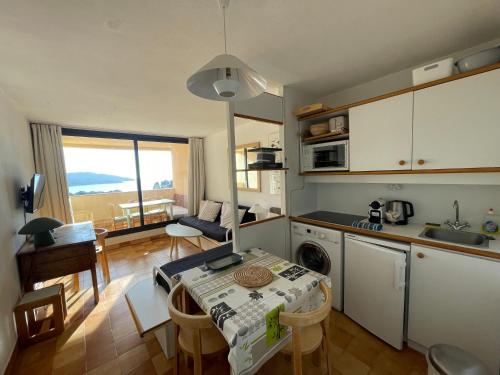 Il comprend une cuisine et un salon avec une table. dans l'établissement Gigaro Sylvabelle Sea Zen 2, à La Croix-Valmer