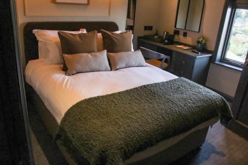 a bedroom with a large bed with pillows at The Wheatley Arms in Ilkley
