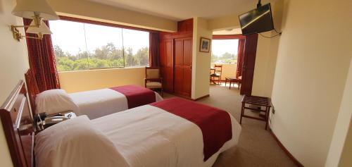 a hotel room with two beds and a window at El Cabildo Hotel in Arequipa