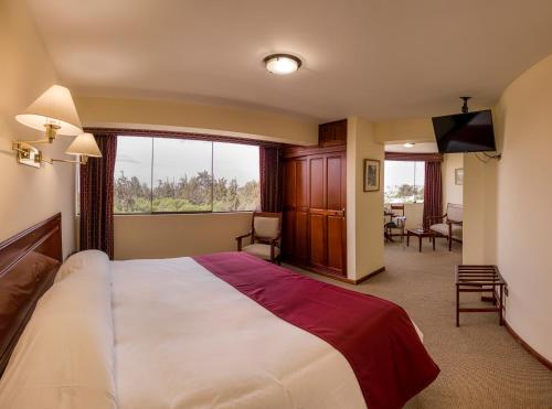 a bedroom with a large bed and a large window at El Cabildo Hotel in Arequipa