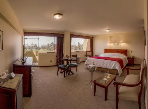 a hotel room with a bed and tables and chairs at El Cabildo Hotel in Arequipa