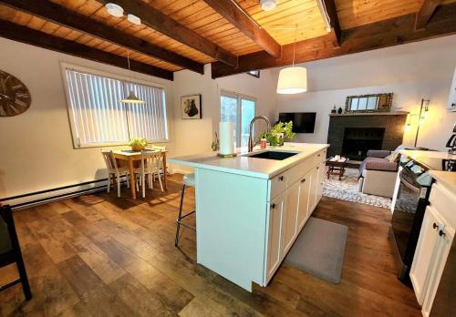 a kitchen with a sink and a living room at Cozy Ski Chalet in the Heart of the Poconos in Tobyhanna