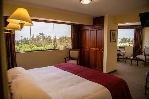 a bedroom with a large bed and a large window at El Cabildo Hotel in Arequipa
