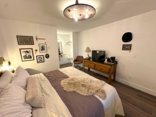 a bedroom with a bed and a desk with a television at Inn History Tombstone in Tombstone