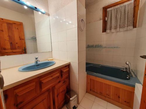 une salle de bain avec un lavabo et une baignoire dans l'établissement Chalet familial cosy avec cheminée, 5 pers. à La Plagne - FR-1-353-135, à La Plagne Tarentaise