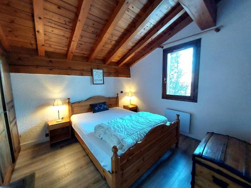 - une chambre avec un lit en bois, deux lampes et une fenêtre dans l'établissement Chalet familial cosy avec cheminée, 5 pers. à La Plagne - FR-1-353-135, à La Plagne Tarentaise