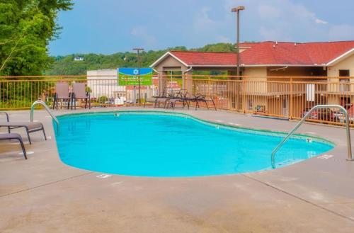 a large swimming pool at a resort with chairs at 1BR2 bath log cabin sleeps 6- walk to Titanic Museum and 5 miles from Dollywood! in Pigeon Forge