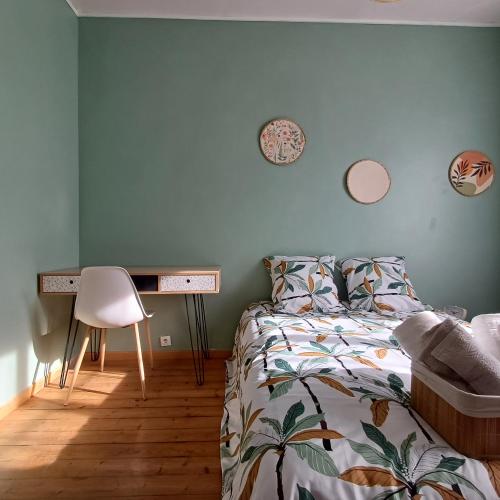 une chambre avec un lit et un bureau avec une chaise dans l'établissement L'Epicerie Maison années 30, à Caen