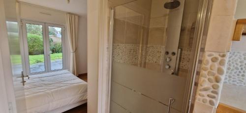 Habitación con ventana, cama y ducha. en Havre de paix près des plages, en Arzon