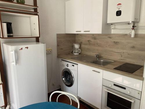 Il comprend une cuisine équipée d'un réfrigérateur blanc et d'un lave-linge. dans l'établissement Appartement T2 moderne, près de la plage, terrasse équipée, parking privé - Le Barcarès - FR-1-782-27, au Barcarès