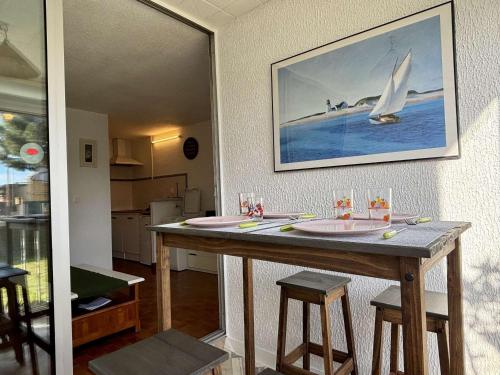 une cuisine avec une table et un voilier sur le mur dans l'établissement Studio cabine climatisé, accès plage à 400m, parking privé, animaux acceptés - FR-1-225-808, à Argelès-sur-Mer