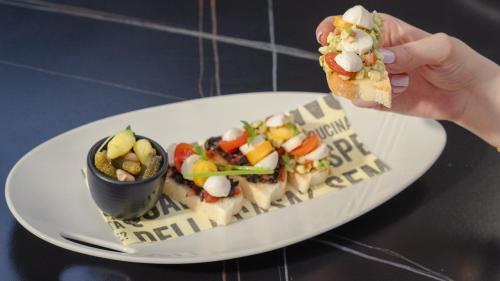 a person holding a piece of food on a plate at The Abdali Boulevard Hotel in Amman