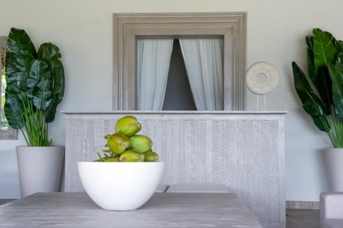 a bowl of fruit sitting on a table in front of a mirror at Zawadi Hotel, Zanzibar in Michamvi