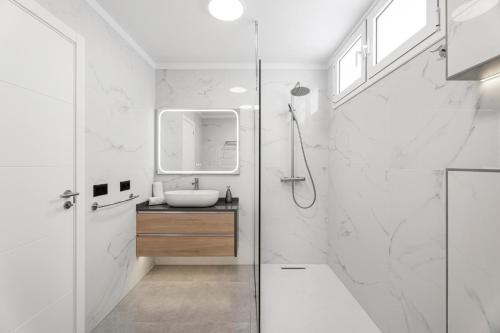 un bagno bianco con lavandino e specchio di Casa El Atlantico a Candelaria