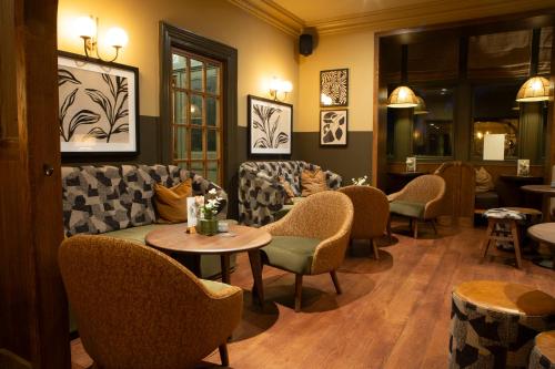 a waiting room with a couch and chairs and tables at The Wheatley Arms in Ilkley