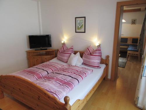 a bedroom with a bed with red and white pillows at Jagerhof in Walchsee