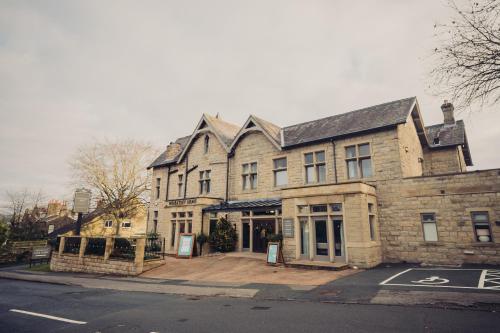 a large stone building on a city street at The Wheatley Arms in Ilkley